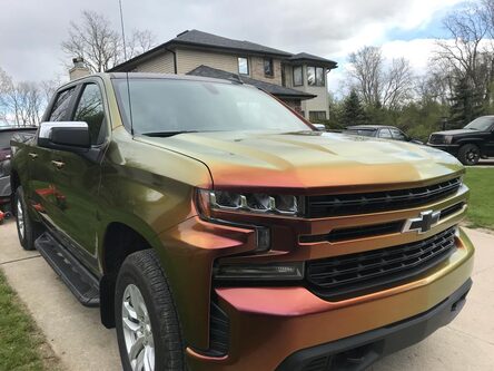 A truck with an orange vehicle wrap in Livonia