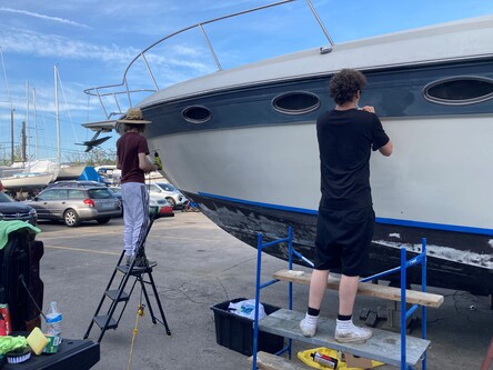 A person vinyl wrapping a boat | Boat wrap graphics Livonia