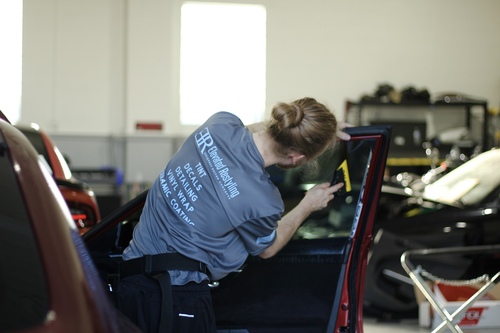 A man applying window tint in Livonia