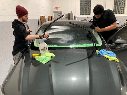 Two workers applying window tinting in Farmington 